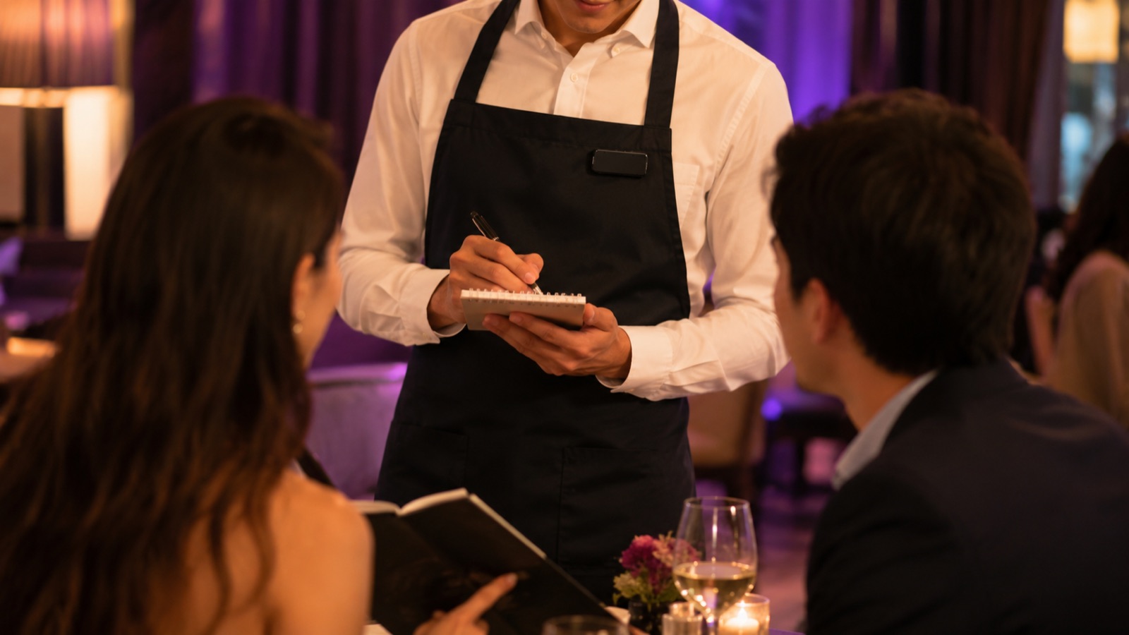 server wearing the Framo badge while taking an order